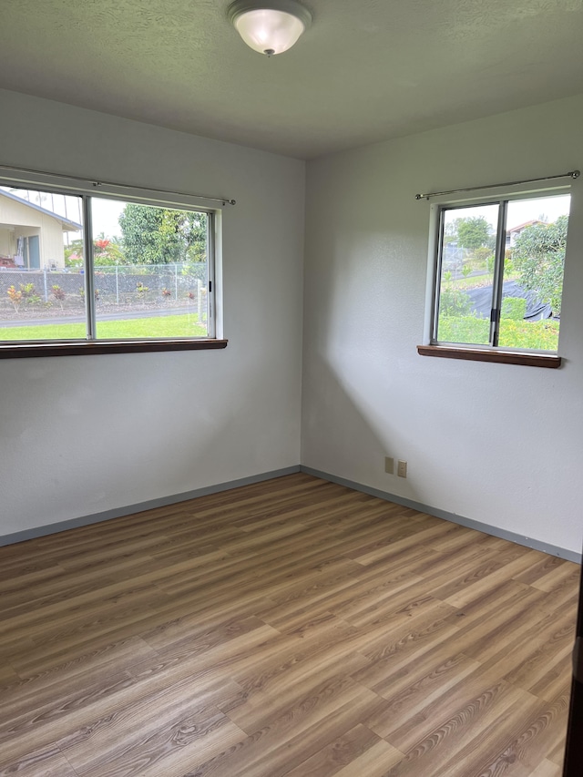 unfurnished room with wood-type flooring