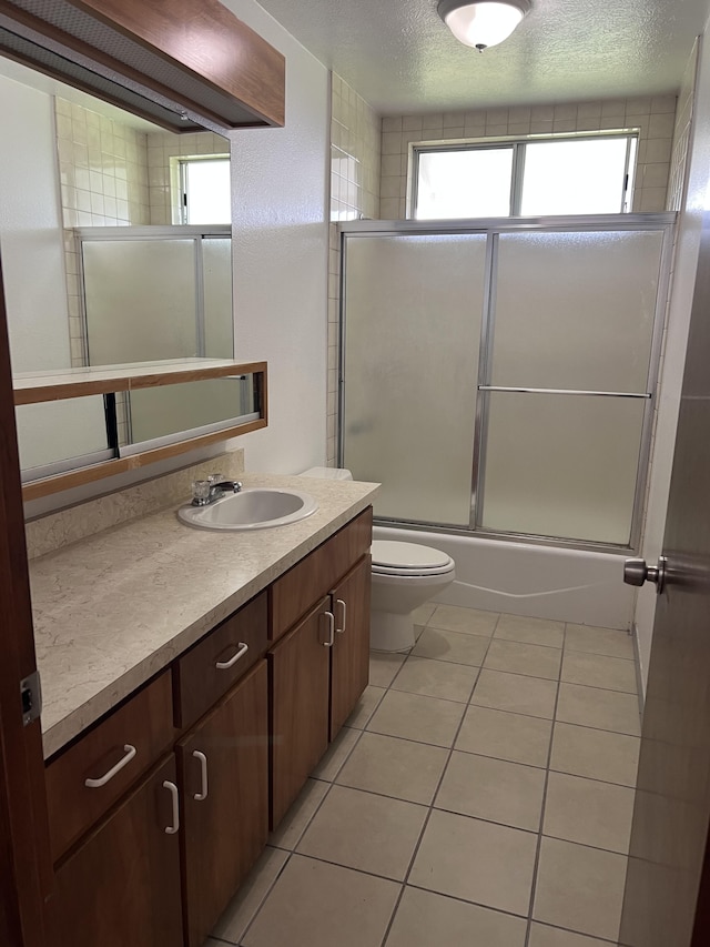 full bathroom with toilet, enclosed tub / shower combo, tile patterned floors, and a wealth of natural light