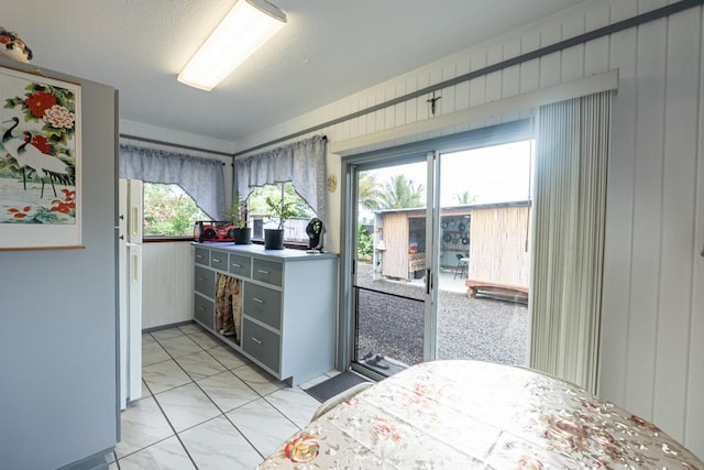 tiled bedroom featuring multiple windows and wooden walls