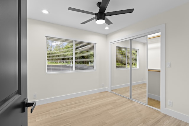 unfurnished bedroom featuring ceiling fan, light hardwood / wood-style flooring, and a closet