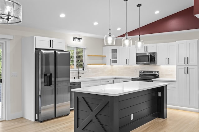 kitchen with white cabinetry, hanging light fixtures, vaulted ceiling, and appliances with stainless steel finishes