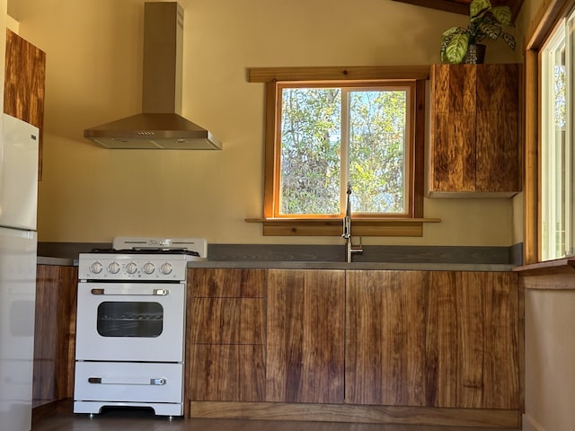 kitchen with white appliances and wall chimney exhaust hood