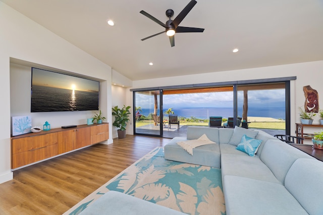 living room featuring wood-type flooring, ceiling fan, and vaulted ceiling