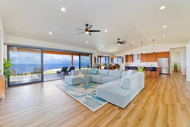 living room featuring a water view, lofted ceiling, plenty of natural light, and light hardwood / wood-style floors