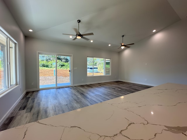 spare room with lofted ceiling, dark hardwood / wood-style floors, ceiling fan, and a healthy amount of sunlight