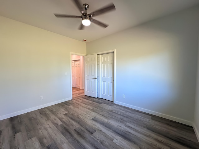 unfurnished bedroom featuring ceiling fan and dark wood-type flooring