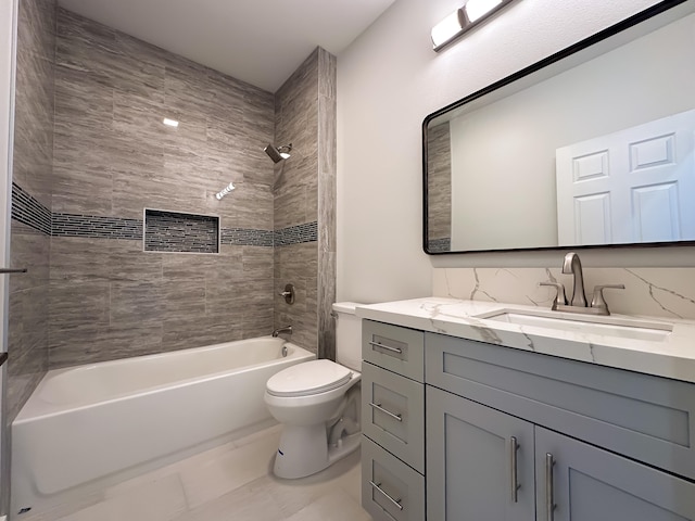 full bathroom with tile patterned floors, vanity, tiled shower / bath combo, and toilet