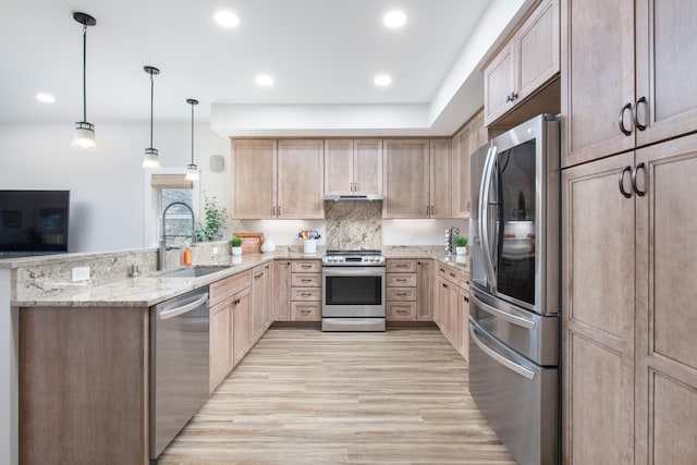 kitchen featuring appliances with stainless steel finishes, light brown cabinets, pendant lighting, and sink