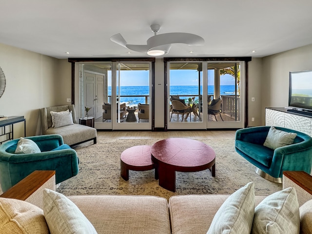 living room featuring light hardwood / wood-style floors, a wall of windows, and ceiling fan