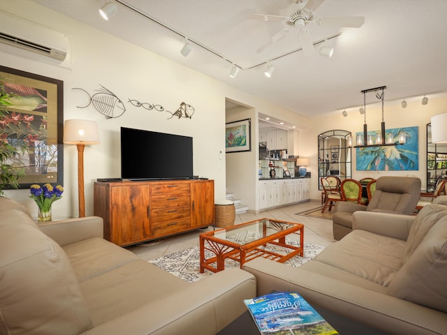 living room with an AC wall unit, light tile patterned flooring, and ceiling fan with notable chandelier