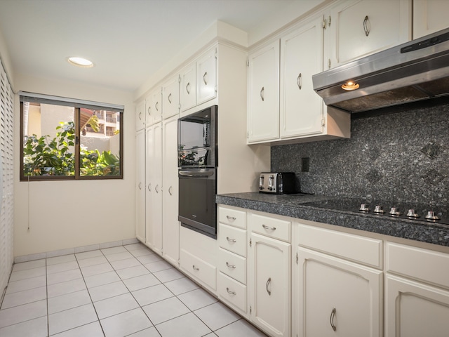 kitchen with backsplash, cooktop, black microwave, light tile patterned floors, and white cabinets