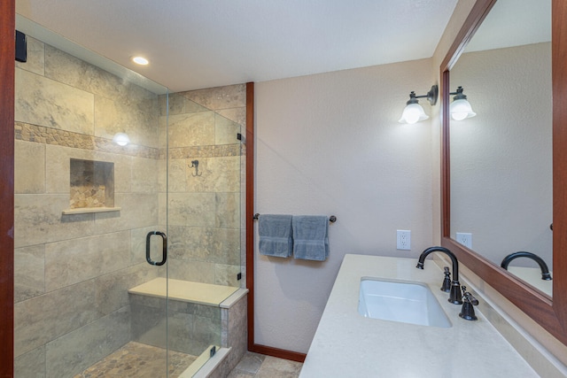 bathroom with walk in shower and vanity