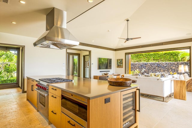 kitchen with appliances with stainless steel finishes, island range hood, a kitchen island, vaulted ceiling, and beverage cooler