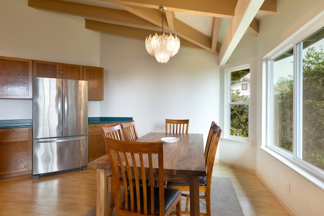 dining space featuring light hardwood / wood-style floors, lofted ceiling with beams, and a notable chandelier