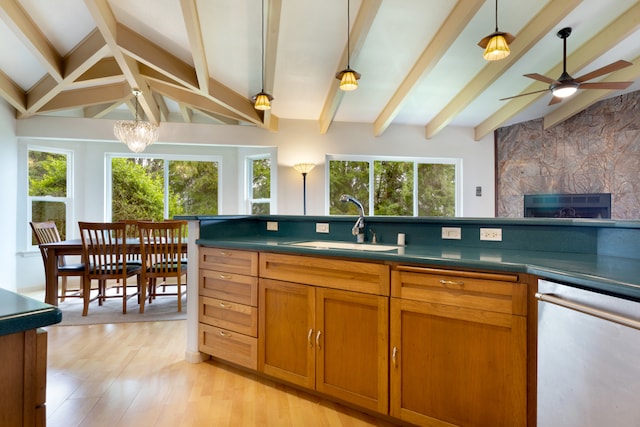 kitchen featuring lofted ceiling with beams, sink, a large fireplace, hanging light fixtures, and light hardwood / wood-style floors