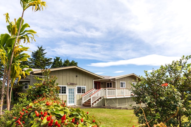 rear view of house with a yard and a deck