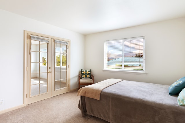 bedroom featuring french doors, carpet flooring, multiple windows, and access to outside