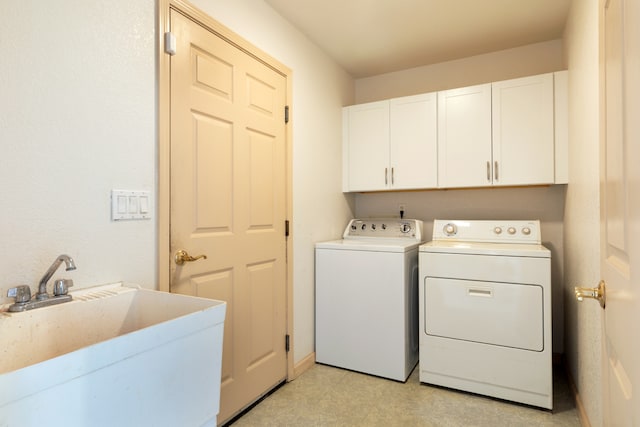 washroom with cabinets, separate washer and dryer, and sink