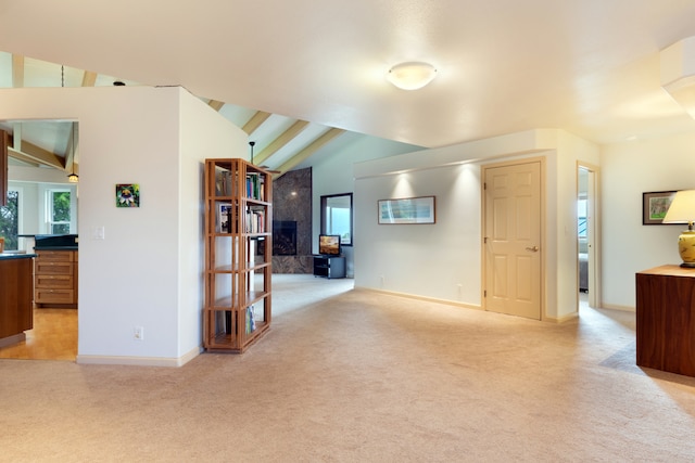 living room featuring lofted ceiling, plenty of natural light, light colored carpet, and a fireplace