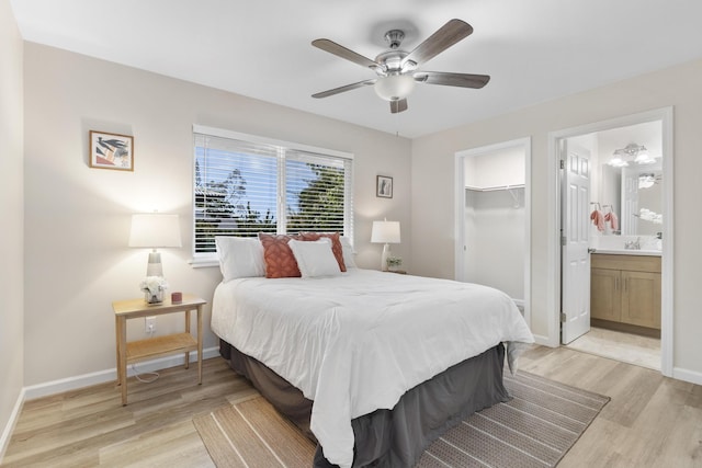 bedroom featuring a spacious closet, ensuite bathroom, ceiling fan, a closet, and light hardwood / wood-style flooring