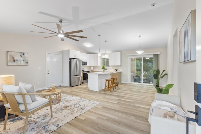 living room with ceiling fan, lofted ceiling, and light hardwood / wood-style floors