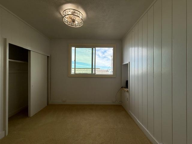 unfurnished bedroom with a closet and light carpet