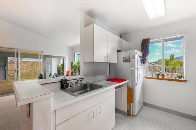 kitchen featuring white cabinets, sink, white refrigerator, and a healthy amount of sunlight