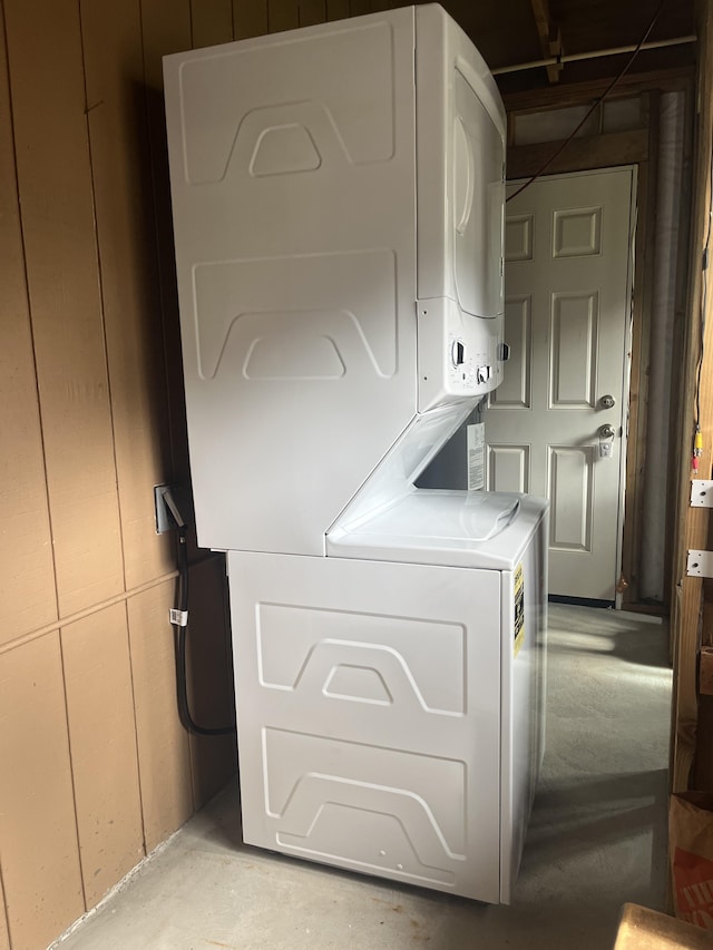 clothes washing area featuring stacked washer and clothes dryer