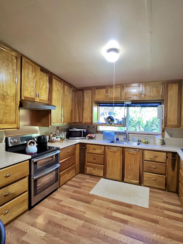 kitchen featuring stainless steel appliances, sink, and light hardwood / wood-style flooring