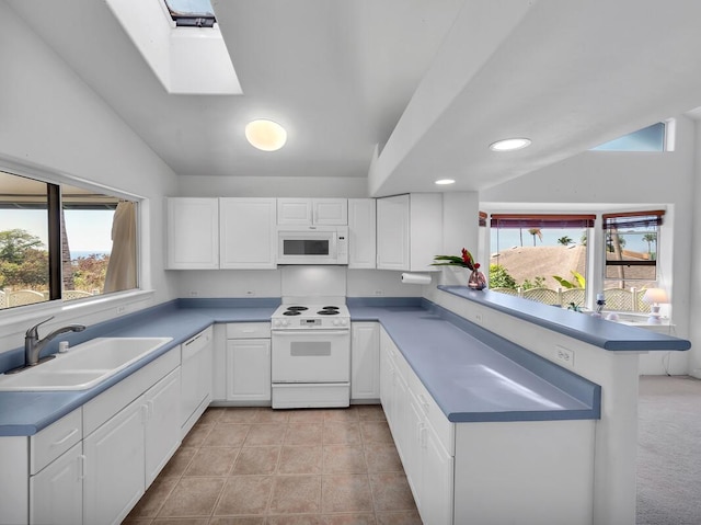 kitchen featuring lofted ceiling, sink, light tile patterned floors, white appliances, and white cabinets