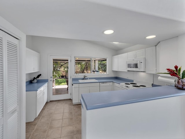 kitchen featuring white cabinetry, sink, kitchen peninsula, and white appliances