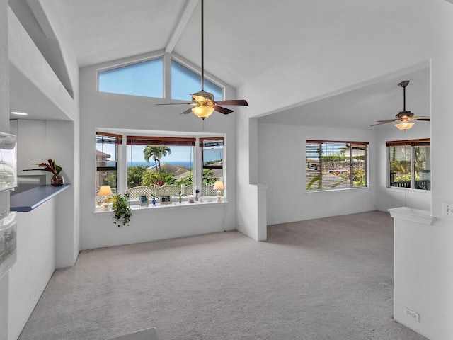 unfurnished living room with vaulted ceiling, ceiling fan, and light carpet