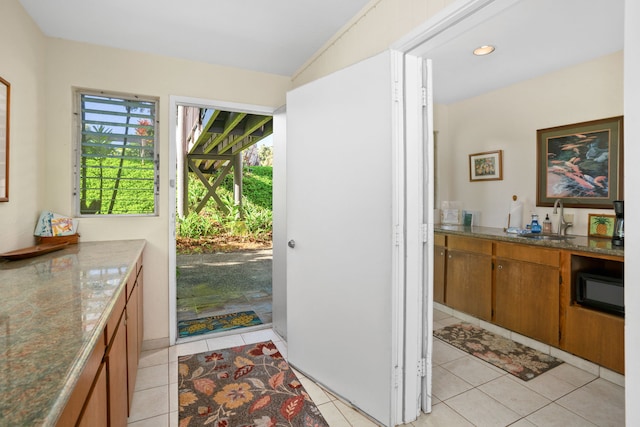 doorway to outside featuring light tile patterned floors and sink