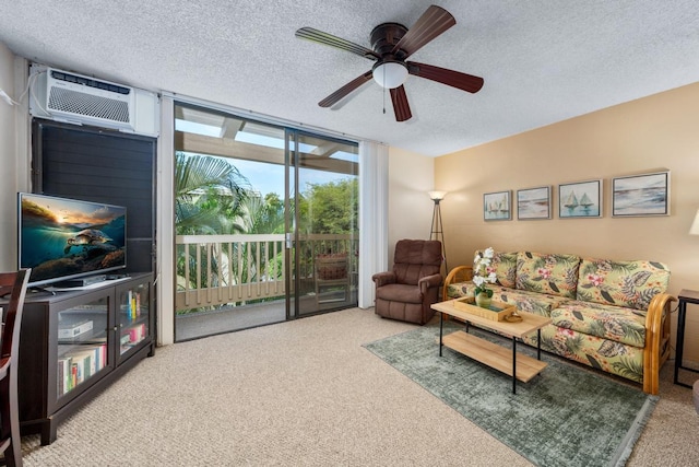 carpeted living room featuring ceiling fan, a wall mounted air conditioner, expansive windows, and a textured ceiling