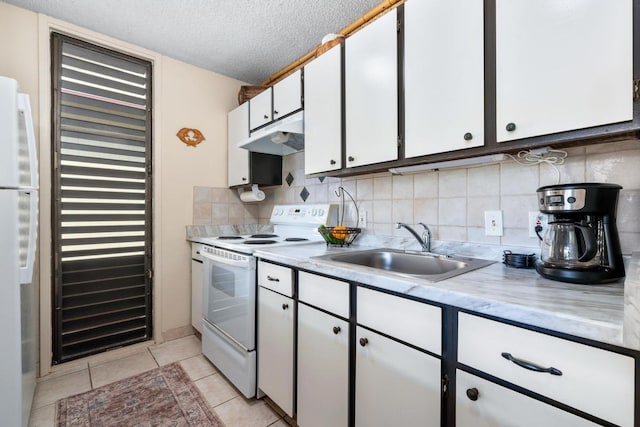 kitchen with sink, a textured ceiling, light tile patterned floors, white appliances, and white cabinets