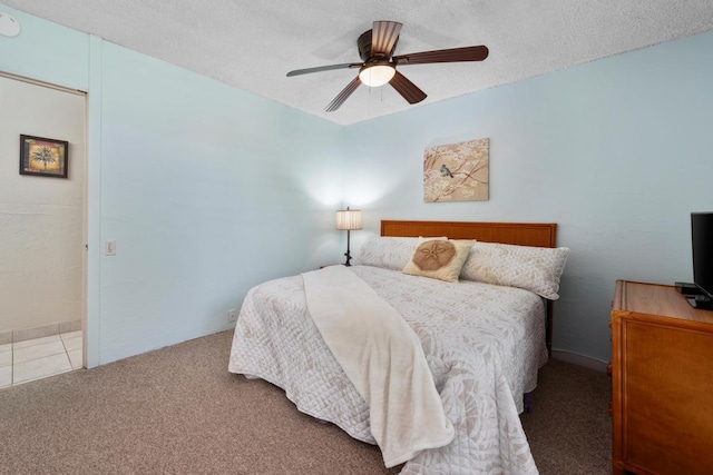 bedroom featuring a textured ceiling, ceiling fan, and carpet