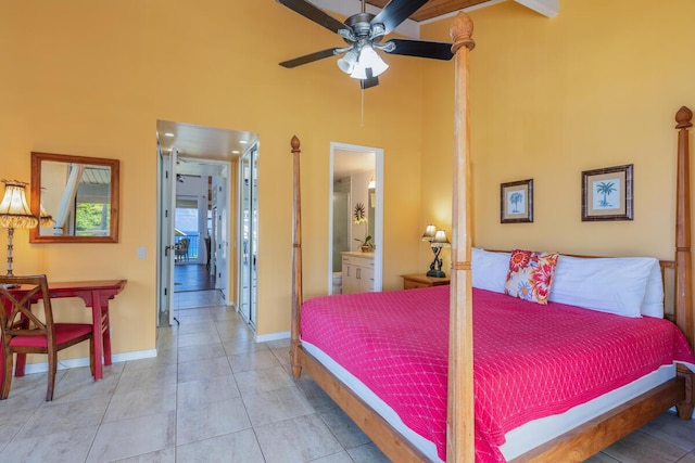 bedroom featuring a towering ceiling, connected bathroom, ceiling fan, and light tile patterned floors