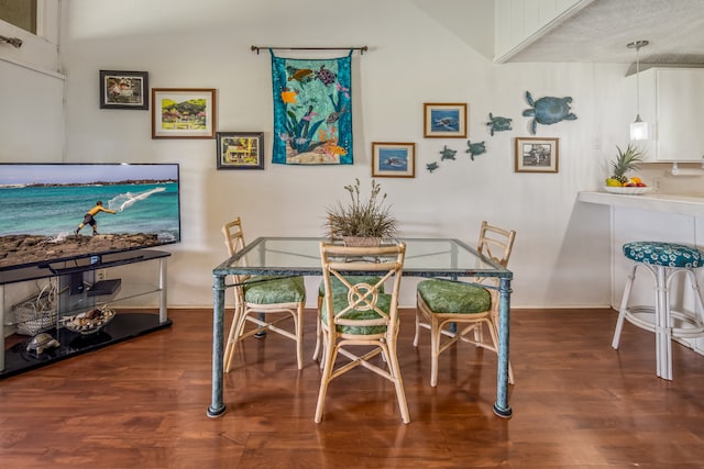 dining room featuring dark hardwood / wood-style flooring and lofted ceiling