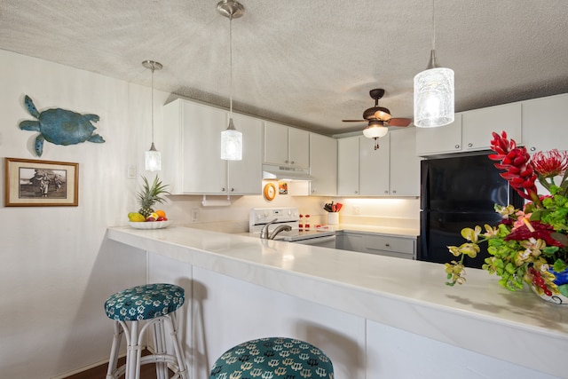 kitchen with electric range, decorative light fixtures, white cabinets, and black fridge