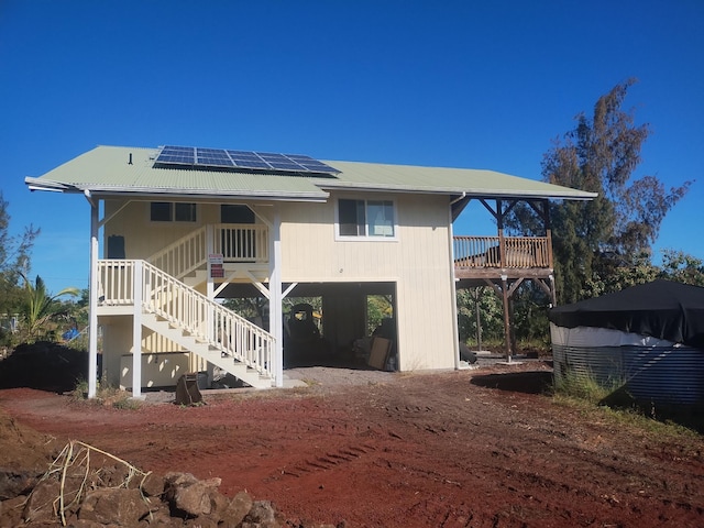 rear view of property with solar panels