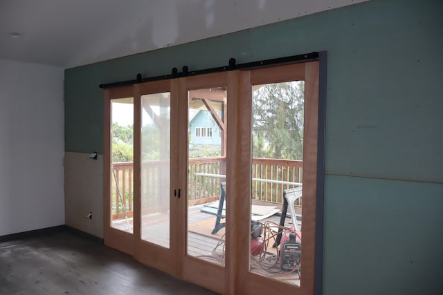 entryway with hardwood / wood-style floors, a barn door, french doors, and a healthy amount of sunlight