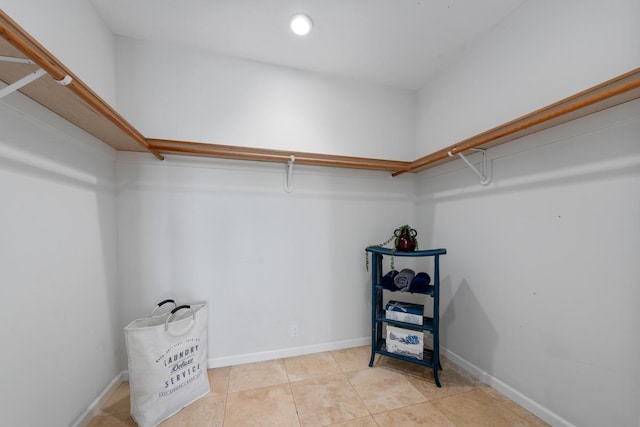 walk in closet with light tile patterned floors