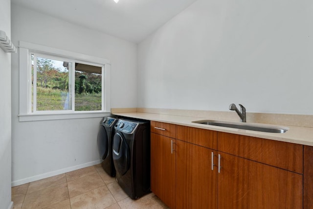 clothes washing area with washer and clothes dryer, light tile patterned flooring, sink, and cabinets