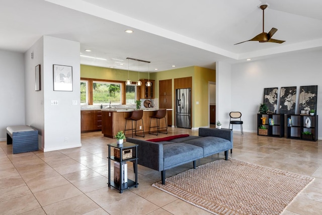 living room with ceiling fan, sink, and light tile patterned flooring