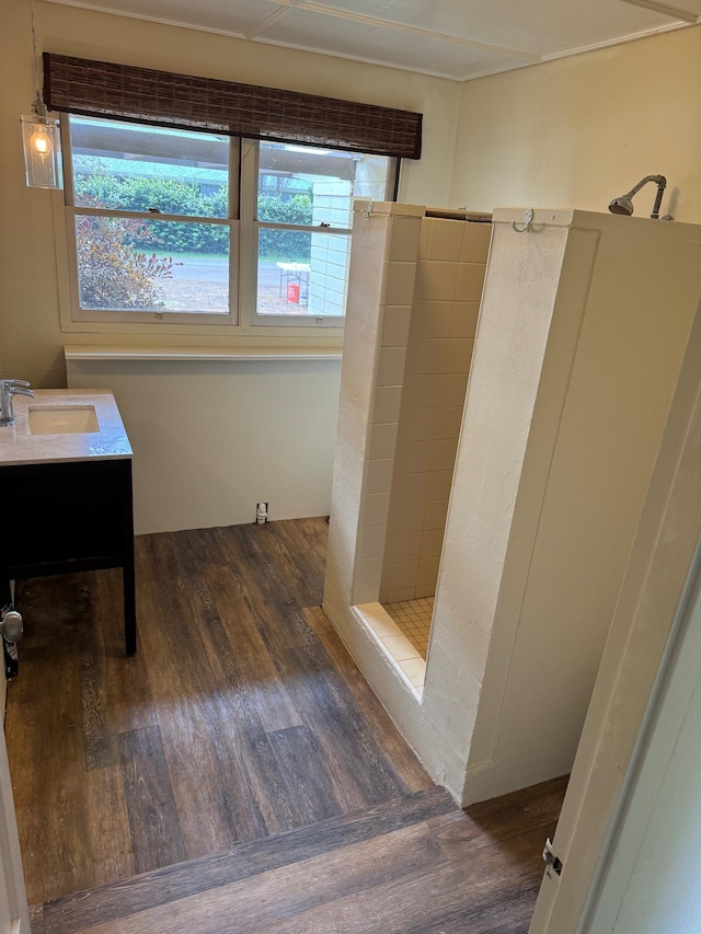 bathroom with vanity, hardwood / wood-style floors, plenty of natural light, and walk in shower