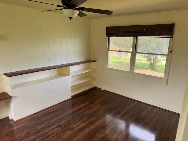 spare room with dark wood-type flooring and ceiling fan