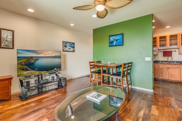 living room with ceiling fan, sink, and dark wood-type flooring