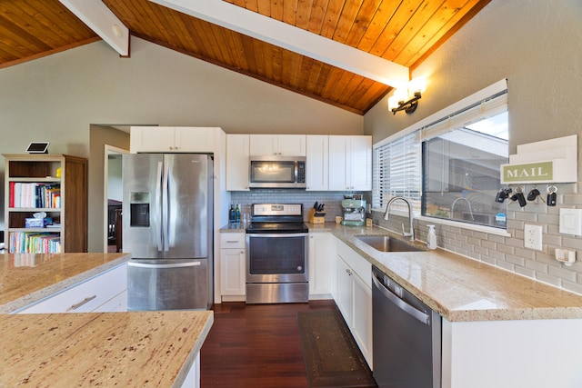 kitchen with tasteful backsplash, white cabinetry, light stone countertops, and appliances with stainless steel finishes