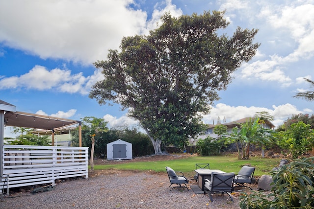 view of yard featuring a storage shed and an outdoor fire pit