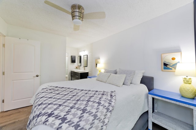 bedroom with ceiling fan, hardwood / wood-style floors, and a textured ceiling